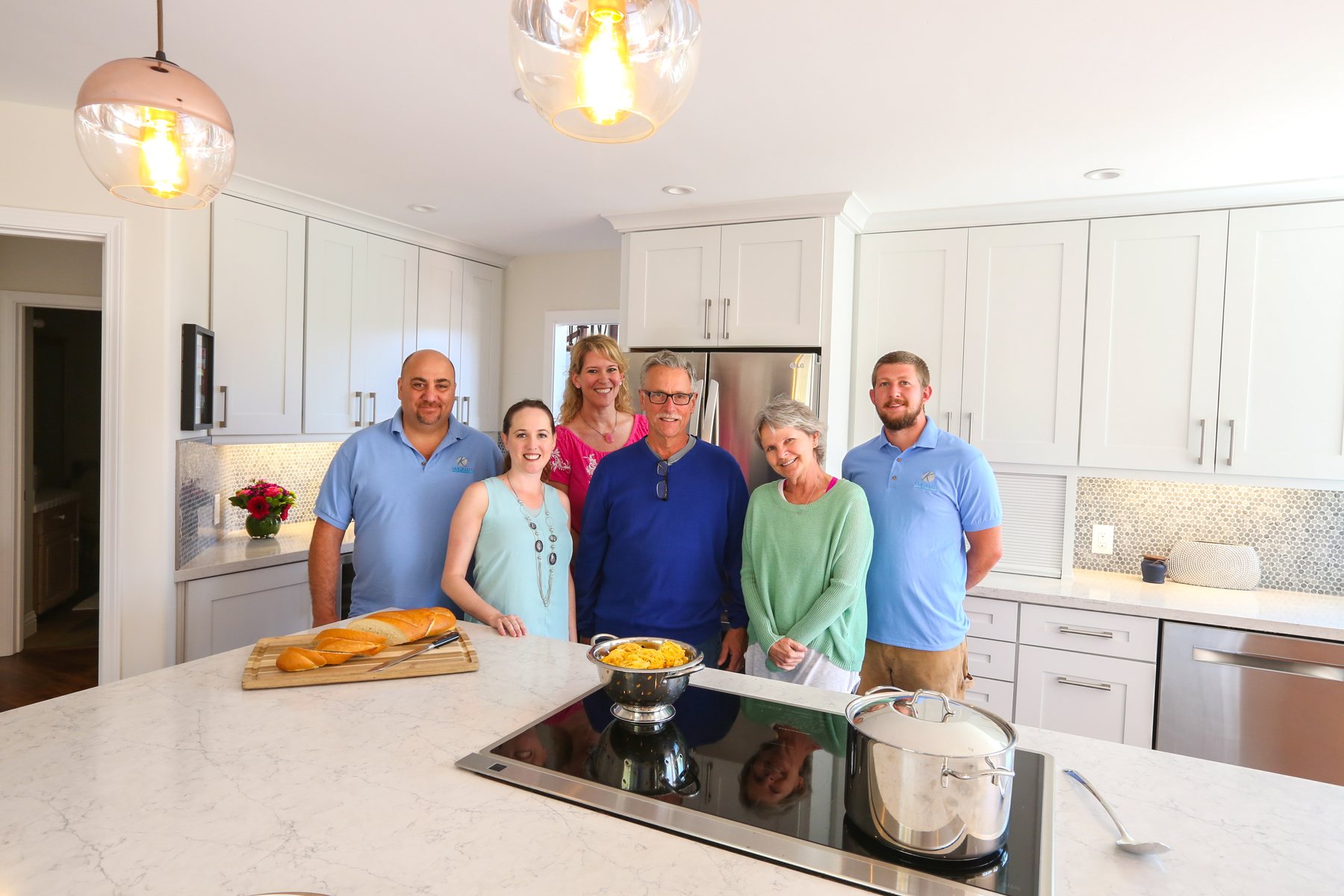 The Kaminskiy team with homeowners in their newly remodeled white kitchen