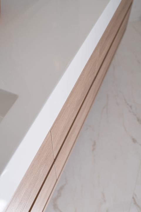 Close-up detail of a floating light-oak vanity with clean modern drawer lines