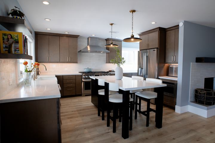 Kitchen looking toward the tiled fireplace, with the island and stainless range in view