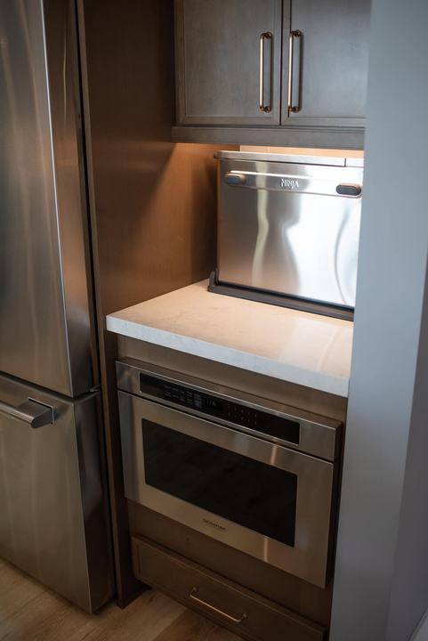 Appliance garage holding a countertop oven above a built-in microwave drawer