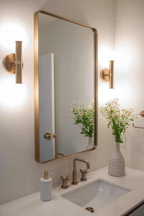 Hall bathroom vanity with brass faucet and mirror