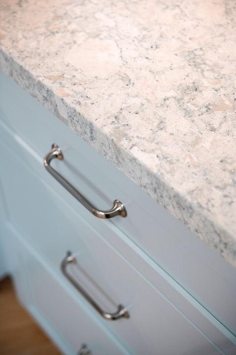 Cambria Montgomery quartz countertop edge with Top Knobs cabinet pulls on blue drawers