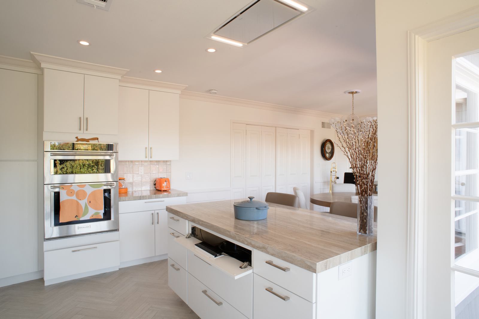 Tilt-down island panel opened to reveal the controls of an induction cooktop hidden under a porcelain counter