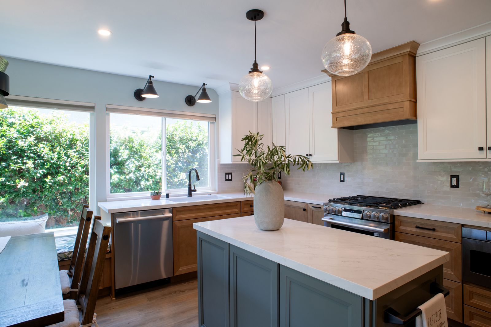 Mira Mesa kitchen remodel with a grey-blue island, glass pendants, a garden window over the sink and wide-plank floors