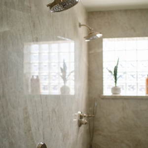 Dual Brizo Invari showerheads on seamless Taj Mahal quartzite slab shower wall