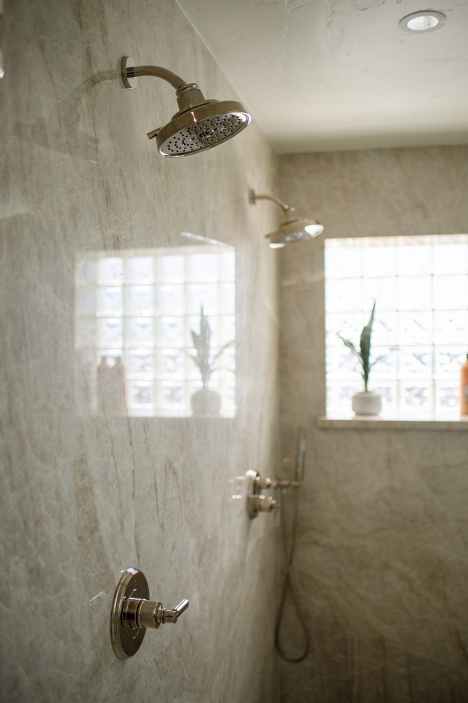 Dual Brizo Invari showerheads on seamless Taj Mahal quartzite slab shower wall
