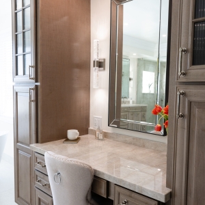 Oblique shot of makeup vanity with quartzite top, linen towers and crystal-rod sconce lighting
