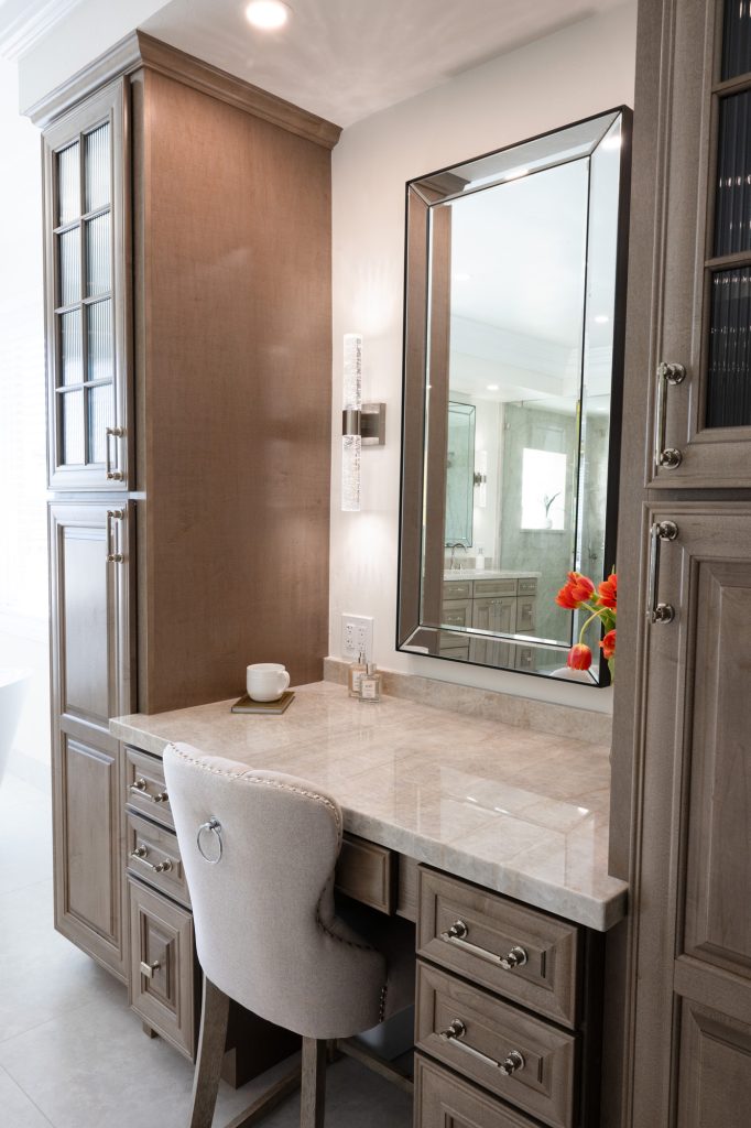 Oblique shot of makeup vanity with quartzite top, linen towers and crystal-rod sconce lighting