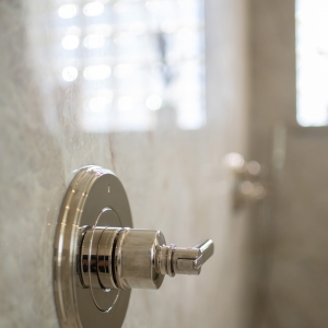 Polished-nickel shower valve trim mounted on polished Taj Mahal quartzite slab
