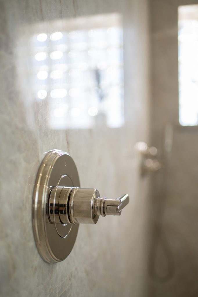 Polished-nickel shower valve trim mounted on polished Taj Mahal quartzite slab