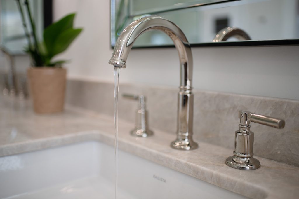 Brizo Invari widespread faucet running over Perla Venata quartzite counter and under-mount sink