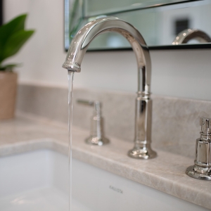 Brizo Invari widespread faucet running over Perla Venata quartzite counter and under-mount sink