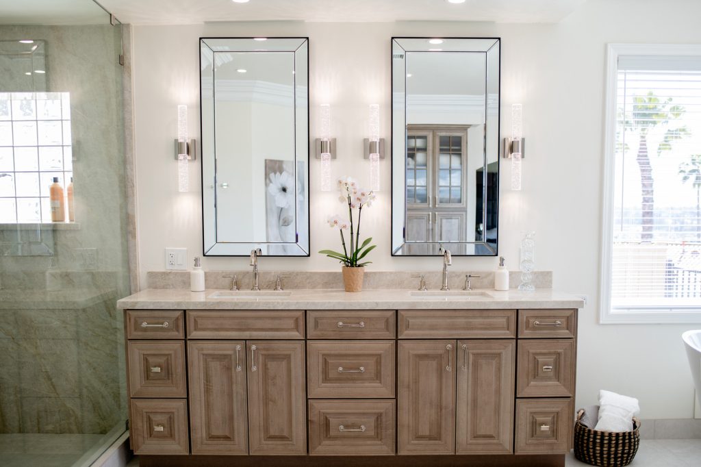 Symmetrical front view of twin sinks, polished-nickel faucets and orchid centerpiece on quartzite countertop.