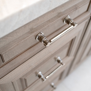Vertical view highlighting polished-nickel drawer pull and thick Perla Venata quartzite countertop edge.