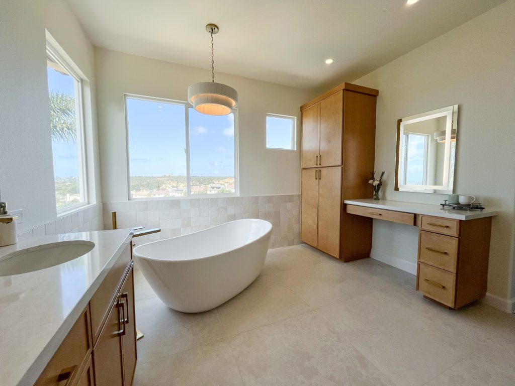 Full room view of tub, vanity, makeup area, and panoramic windows.