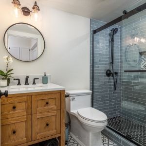 Guest bath with patterned floor and blue shower tile
