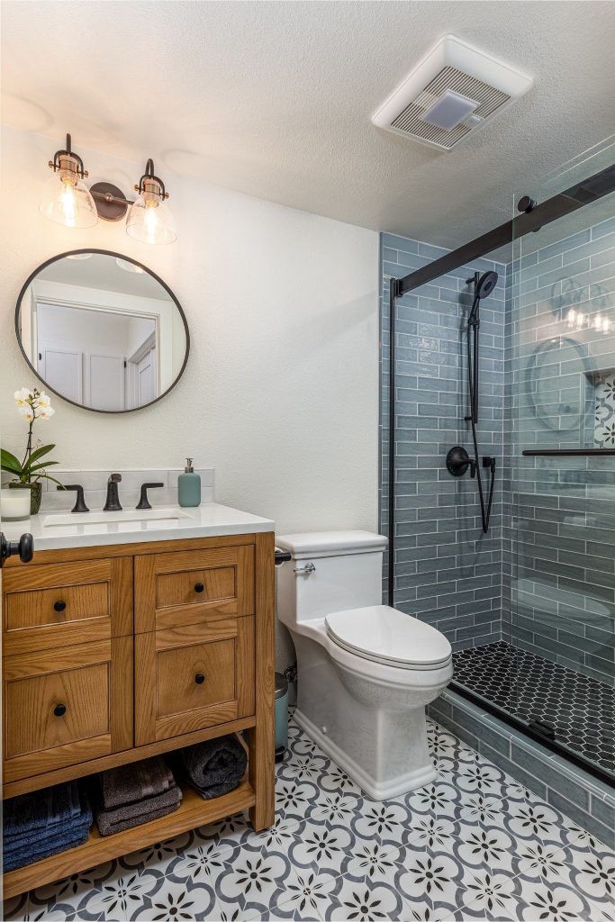 Guest bath with patterned floor and blue shower tile