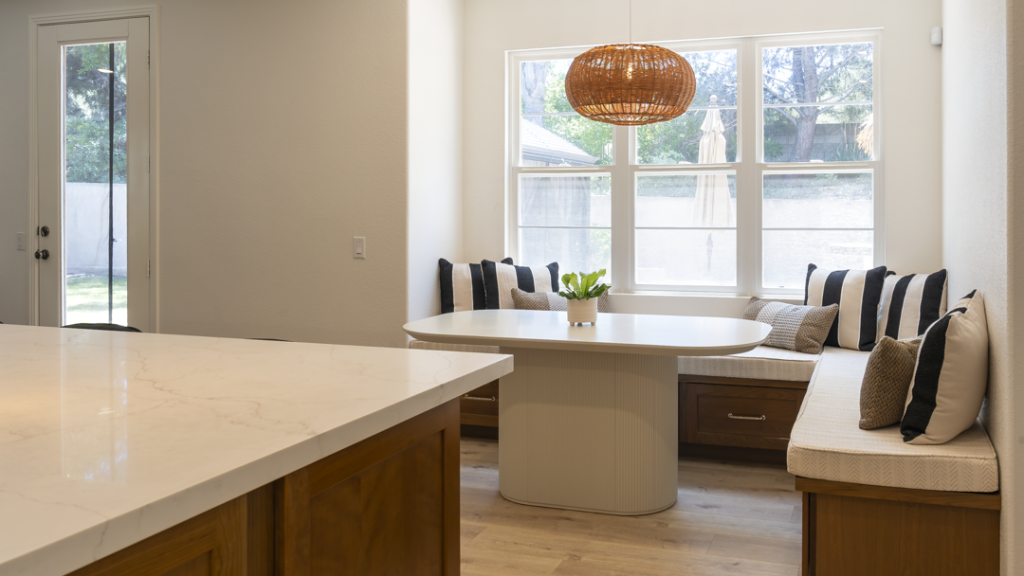 View from island to banquette and patio door, highlighting quartz surface and seamless indoor-outdoor flow
