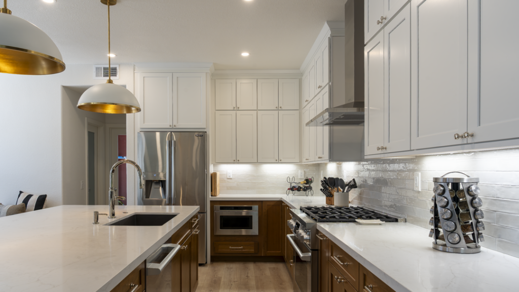 Cooking wall with stainless range and hood, stacked white cabinets, walnut lowers, and glossy subway-tile backsplash