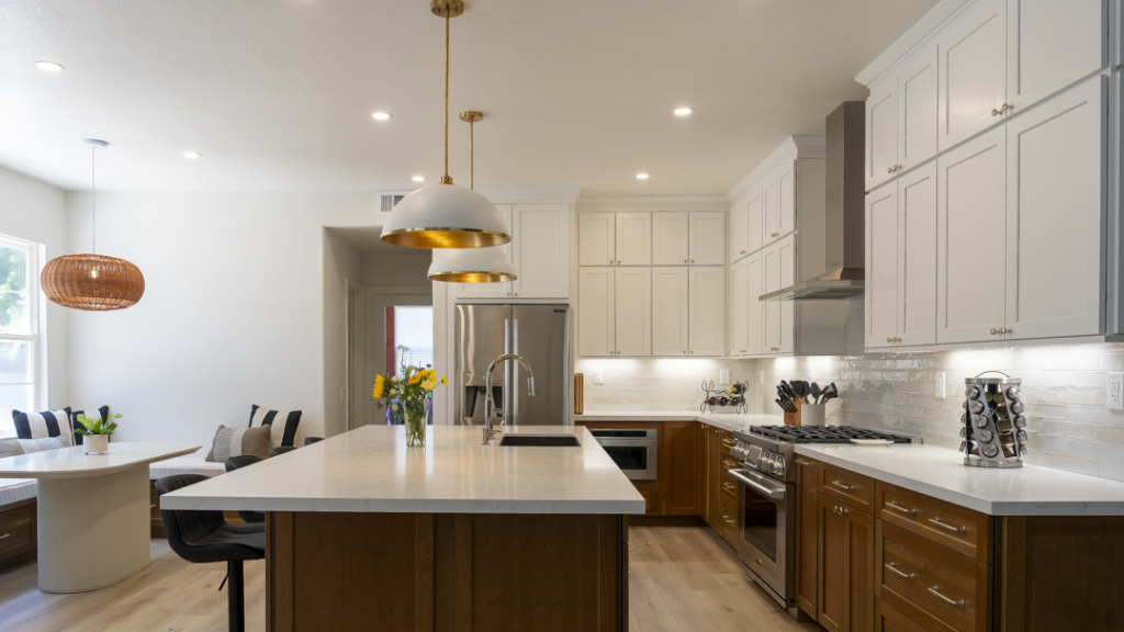 Perspective showing two-tone kitchen, large island, built-in banquette seating, rattan pendant, and recessed LEDs