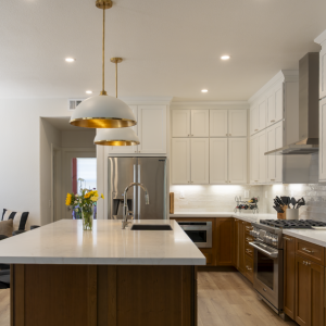 Perspective showing two-tone kitchen, large island, built-in banquette seating, rattan pendant, and recessed LEDs