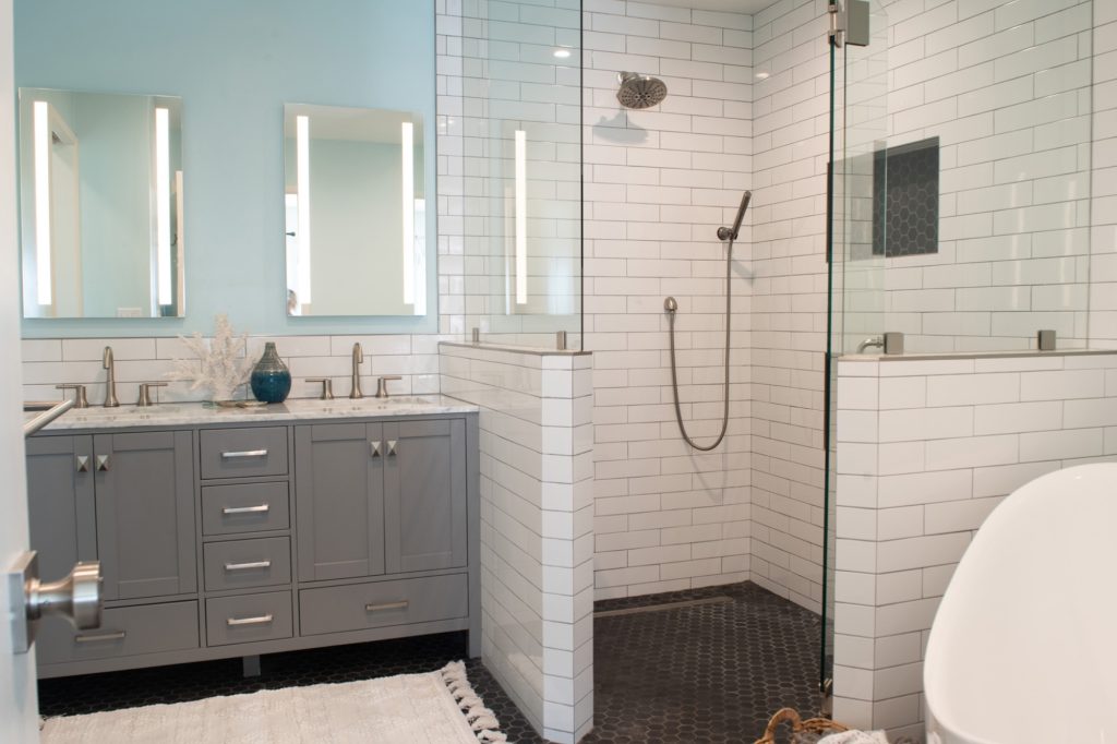Bathroom with illuminated mirrors above a gray vanity 2025 Trend