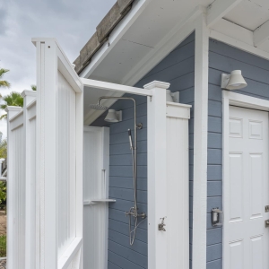 White outdoor shower enclosure with rain head