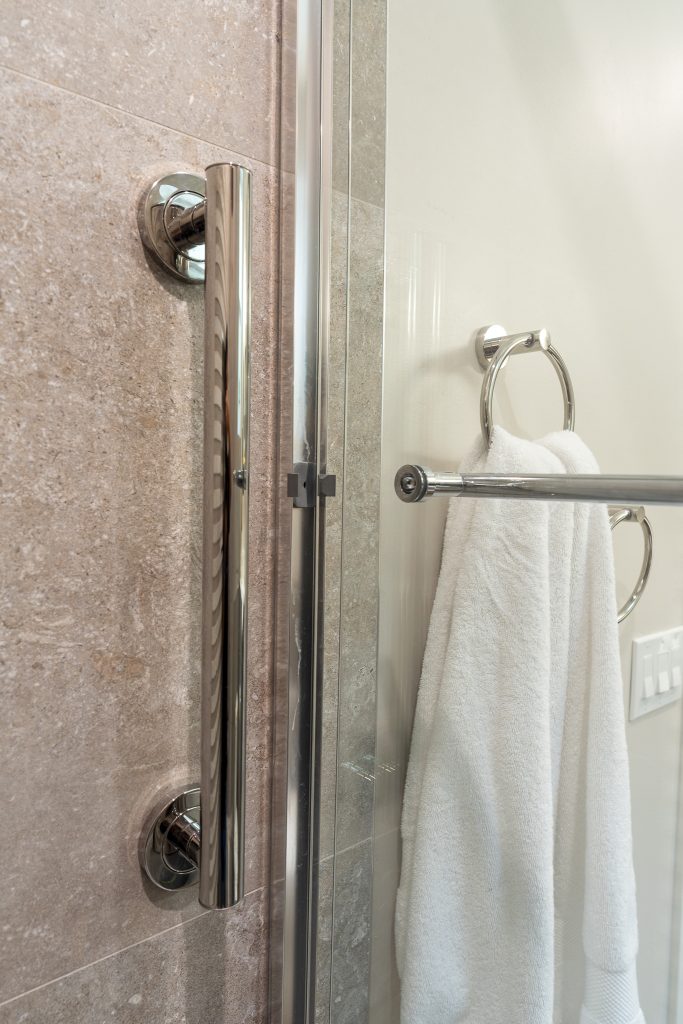 Chrome shower door handle and towel ring detail