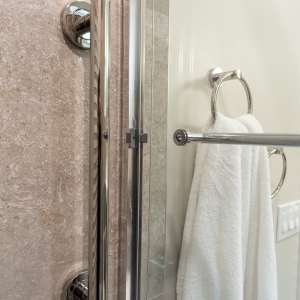 Chrome shower door handle and towel ring detail