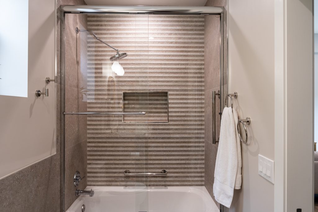 Striped Porcelanosa wall tile in tub-shower with niche