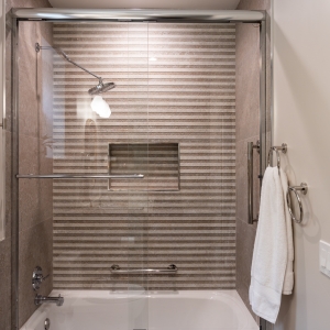 Striped Porcelanosa wall tile in tub-shower with niche