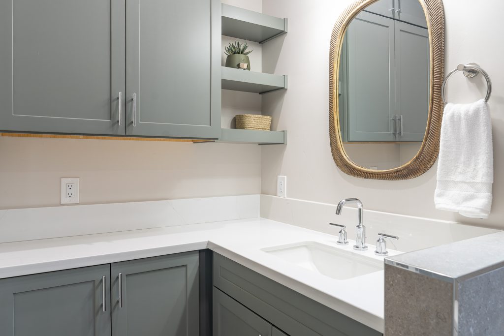 Corner vanity with open shelves and chrome faucet
