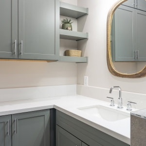 Corner vanity with open shelves and chrome faucet