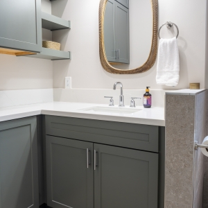 ADU bath with sage vanity, quartz top, brass mirror