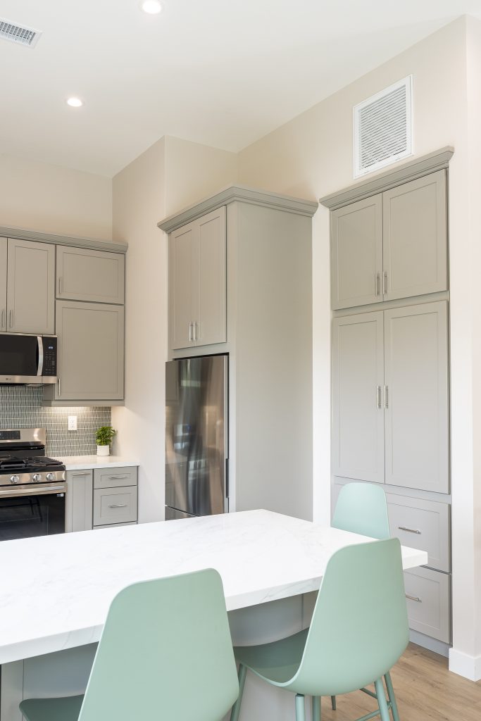 Counter-depth fridge flanked by tall pantry cabinets