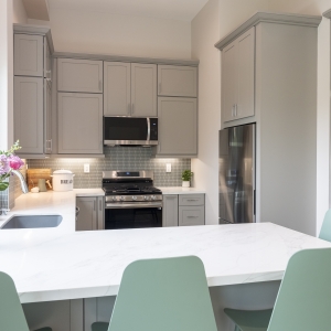 Quartz peninsula with flowers and soft-gray cabinetry