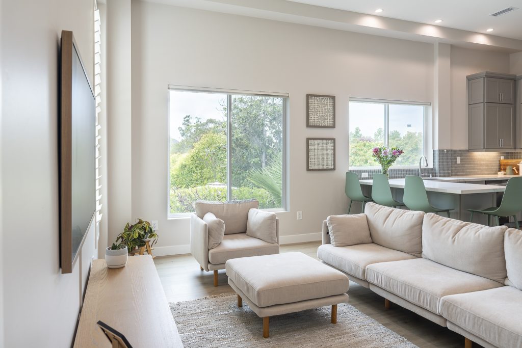 Neutral sofa set facing TV between tall shutters