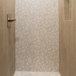 Pebble shower floor meeting a leaf-pattern feature wall in the downstairs bath
