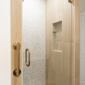 Shower entry showing Shibusa side walls and a recessed niche with glass shelf