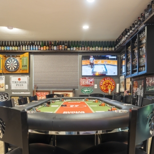 Poker table zone with dartboard cabinet and TV