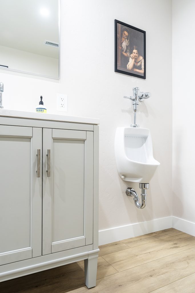 Compact urinal beside vanity&mdash;efficient bath layout