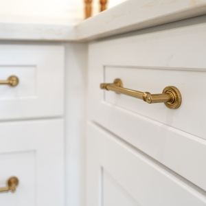 Brass drawer pulls detail on white Shaker base cabinets