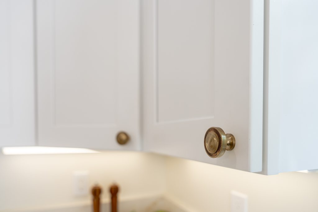 Brass cabinet knobs on white Shaker upper doors