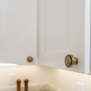 Brass cabinet knobs on white Shaker upper doors