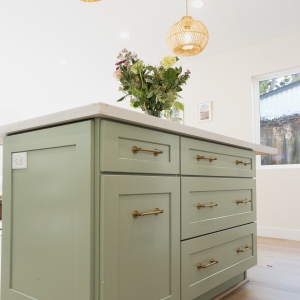 Island drawer stack with brass pulls and integrated outlet