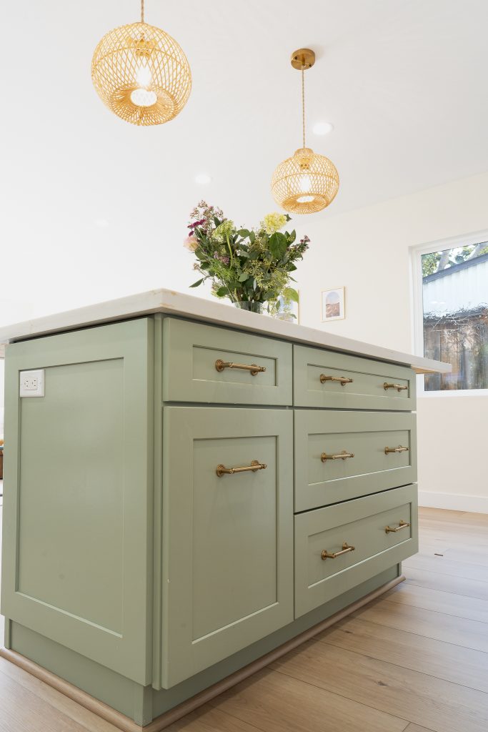 Island drawer stack with brass pulls and integrated outlet