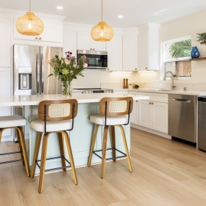 Island overhang with cane stools and warm brass accents