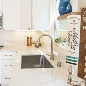 Sink wall with panel-ready Frigidaire dishwasher and quartz return