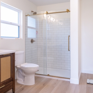 Primary bath double vanity with arched mirrors and brass faucets