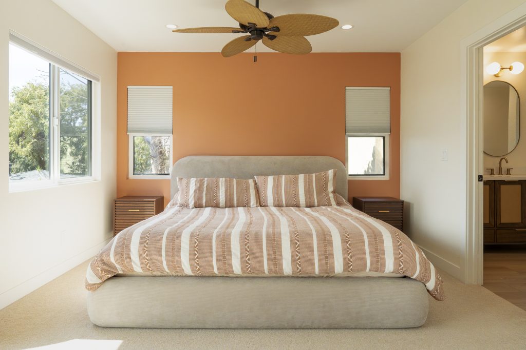 Primary bed wall with terracotta accent and ensuite entry
